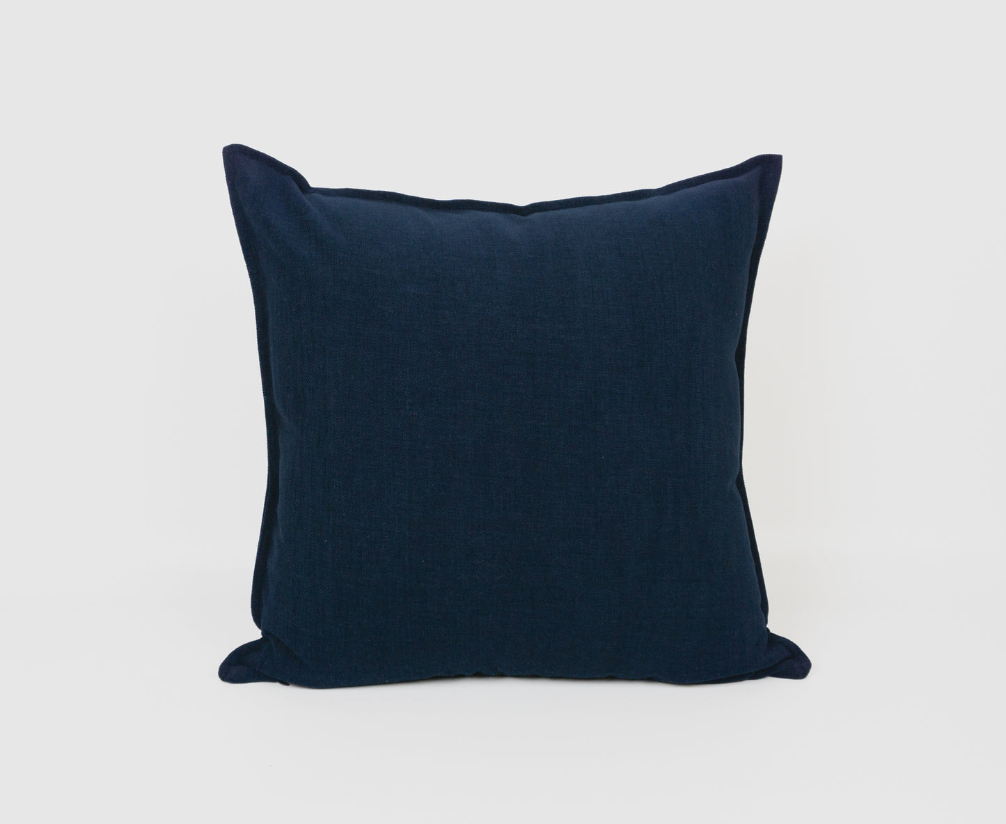 a dark blue pillow on a white background