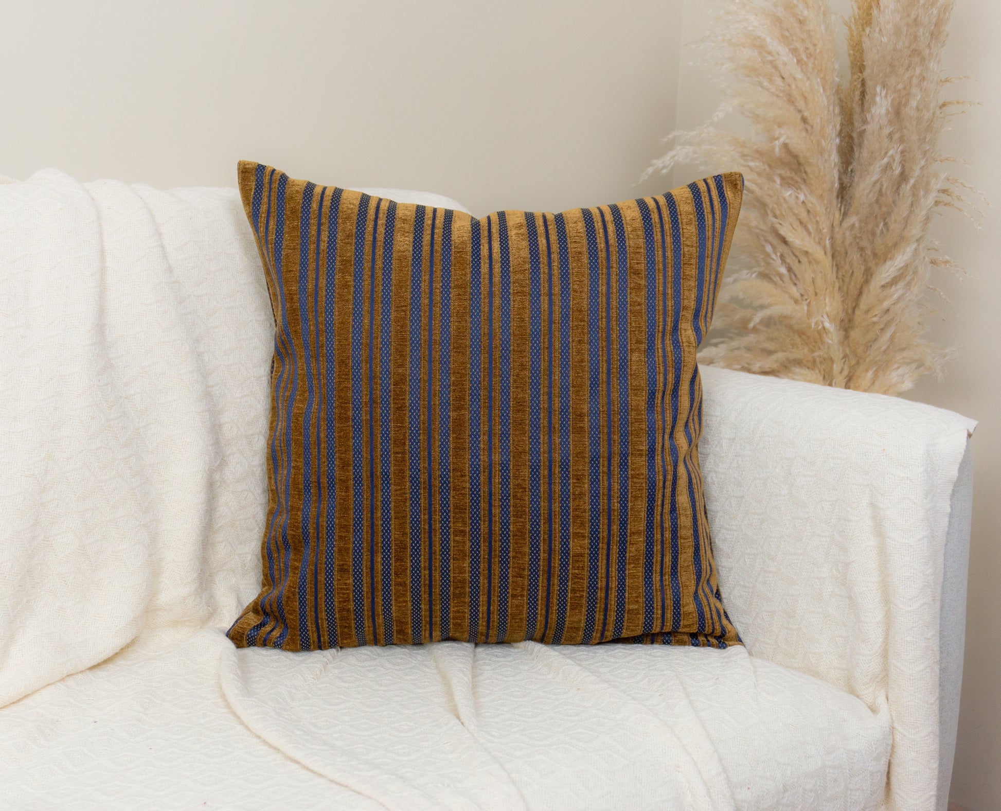 a white couch with a striped pillow on it